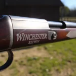 Detailed shot of a 32WIN cartridge in use, showcasing classic firearm design and emphasizing precision in hunting conditions for enthusiasts.