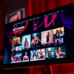 Close-up of a computer screen displaying an adult entertainment website with video thumbnails and vibrant colors.